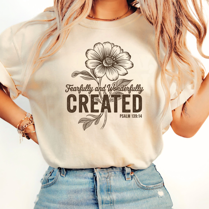 Brown hoodie with Fearfully and Wonderfully Created floral design worn indoors
