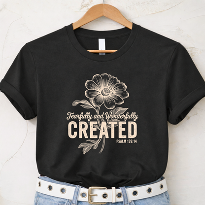Black t-shirt with Fearfully and Wonderfully Created floral design displayed on hanger