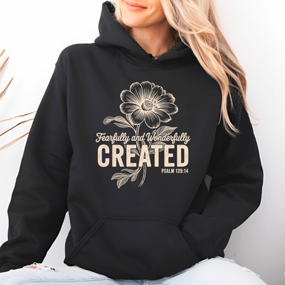 Black hoodie with Fearfully and Wonderfully Created floral design worn in lifestyle setting