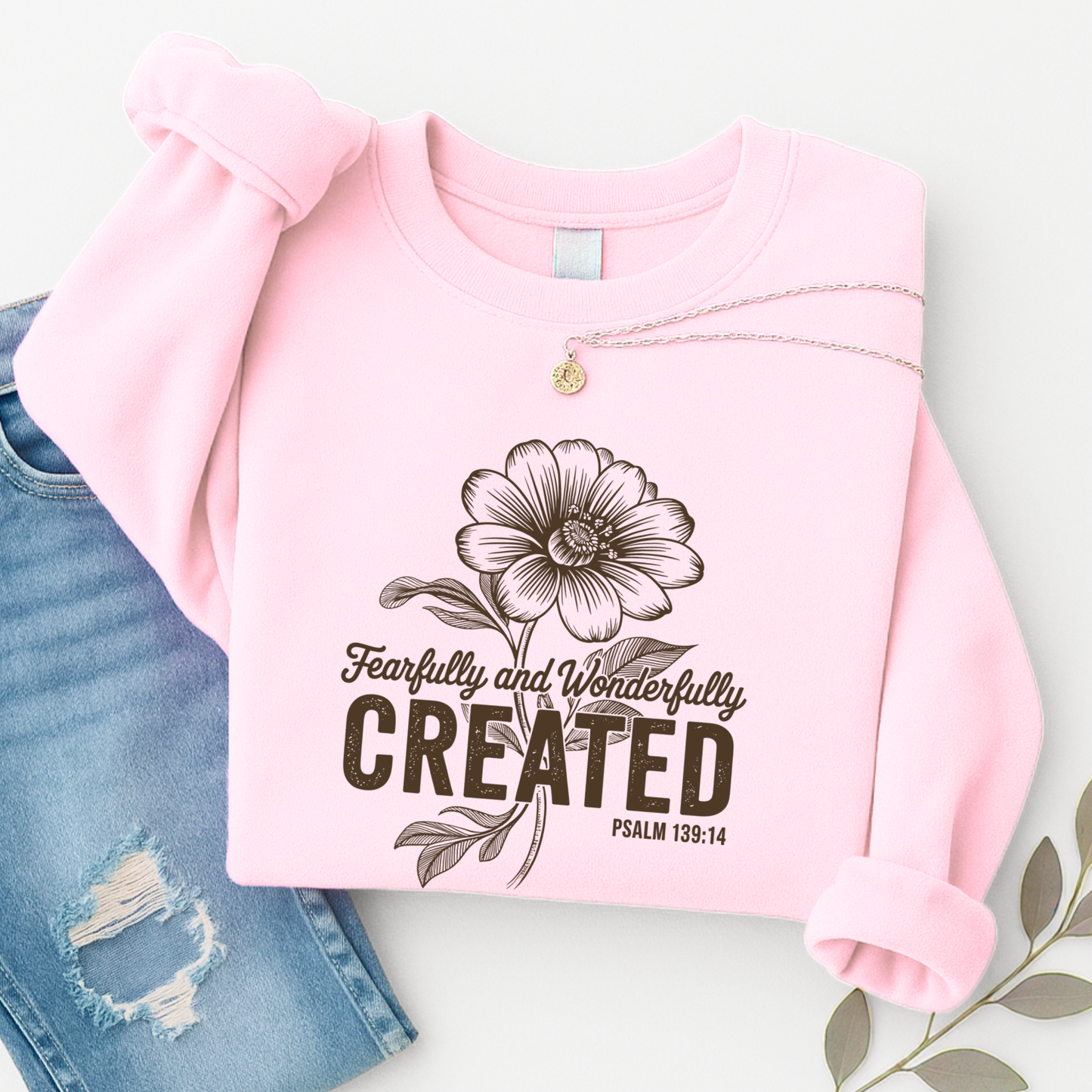 Light pink cropped sweatshirt with Fearfully and Wonderfully Created floral design flat lay