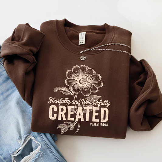 Brown sweatshirt featuring Fearfully and Wonderfully Created floral design with Psalm 139:14 flat lay