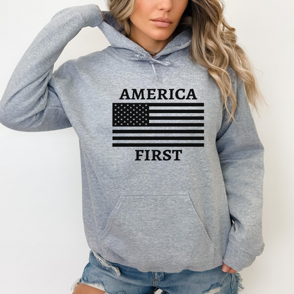 Lady wearing a gray hoodie with 'AMERICA FIRST' text and American flag design on a plain background