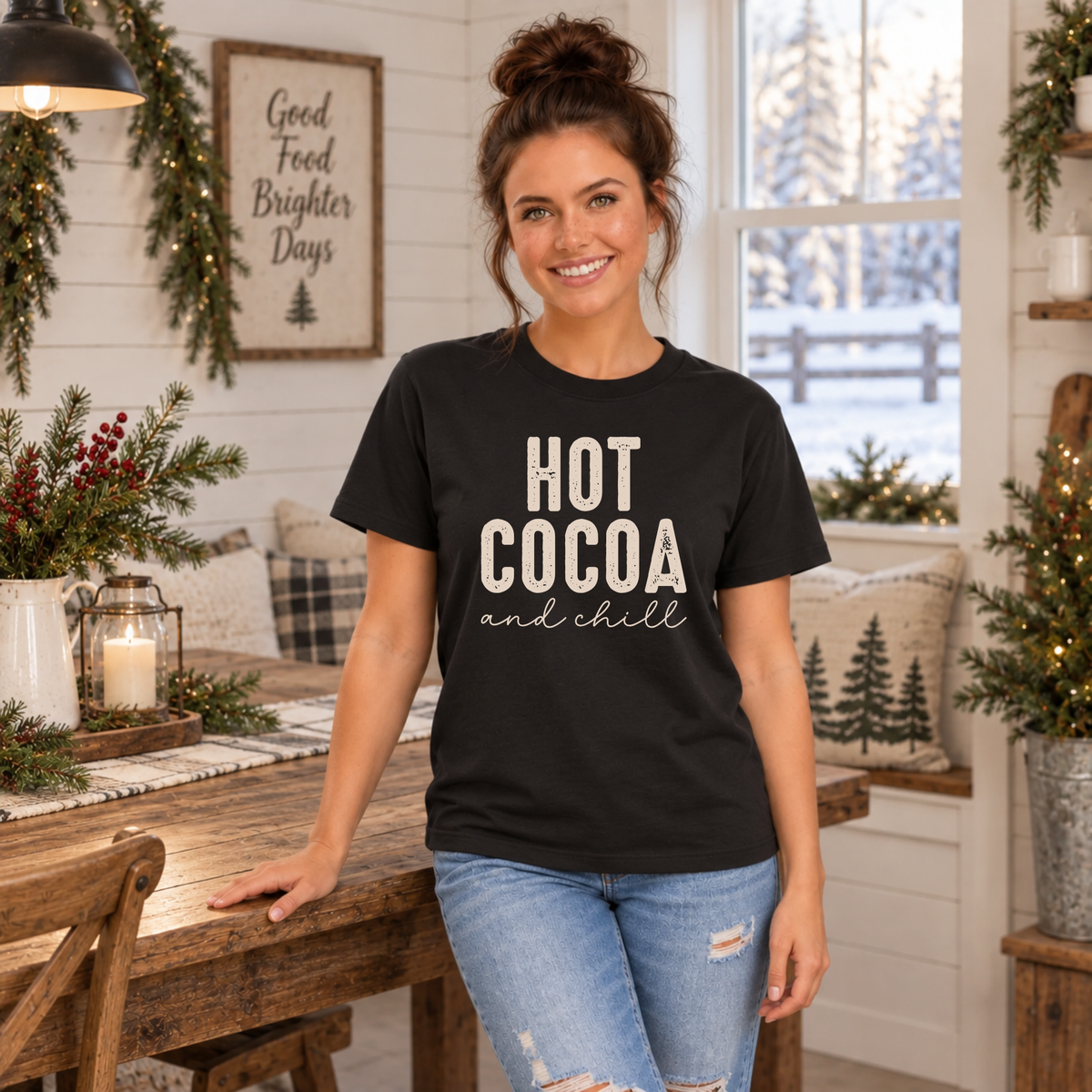 Woman wearing a black T-shirt with Hot Cocoa and Chill design in a cozy winter dining room
