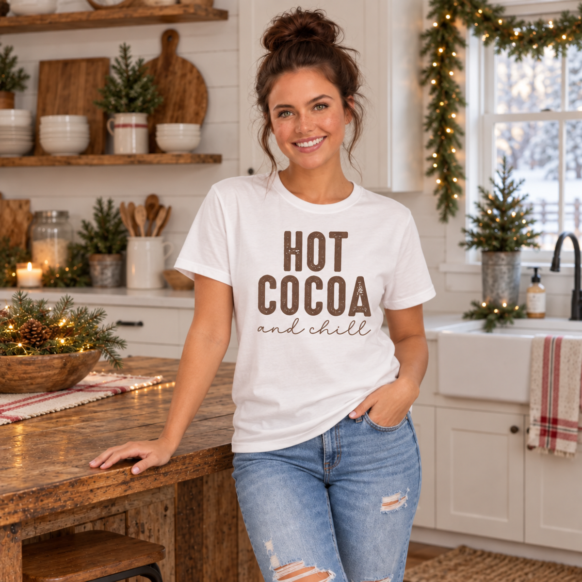 Woman wearing a white Hot Cocoa and Chill T-shirt in a festive farmhouse kitchen