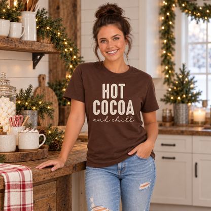 Woman wearing a brown Hot Cocoa and Chill T-shirt beside a rustic cocoa station in a festive kitchen