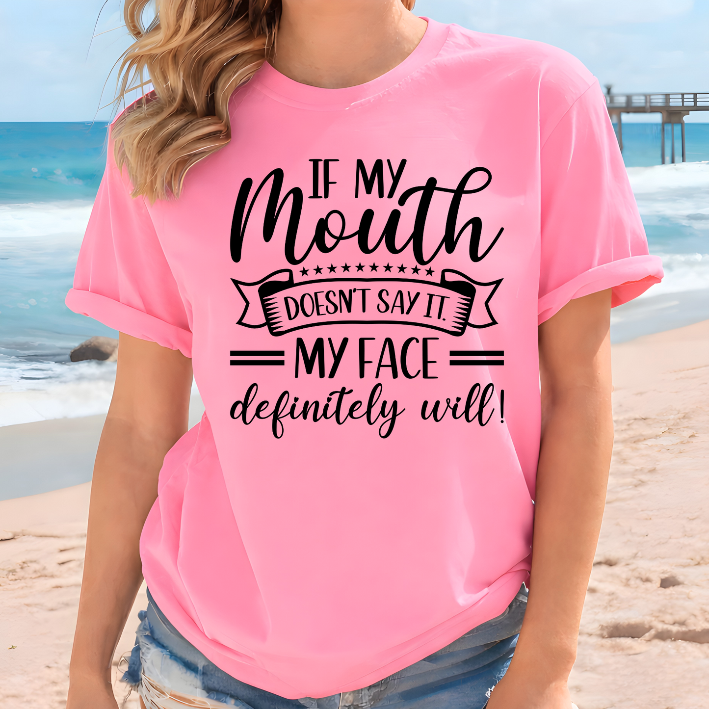 Person wearing a pink t-shirt with a humorous quote on a beach.