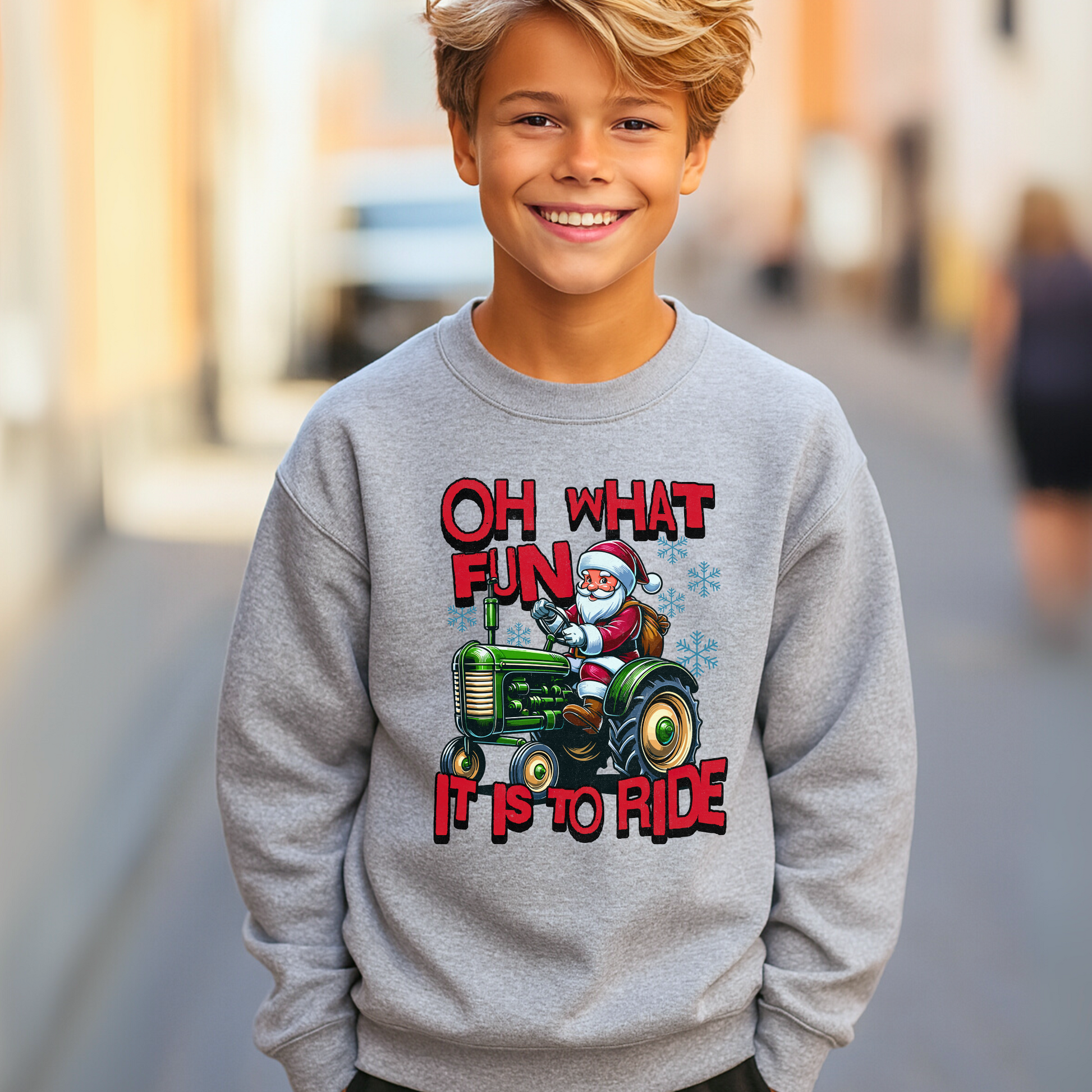 Smiling boy in a gray Santa tractor sweatshirt perfect for kids’ holiday outfits.