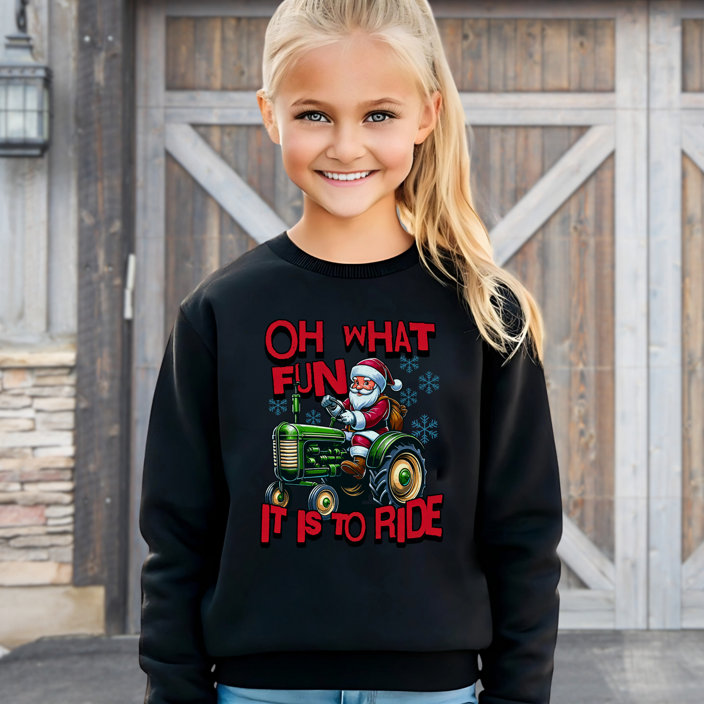 Smiling girl wearing a black youth holiday sweatshirt featuring Santa Claus driving a tractor with festive red lettering.