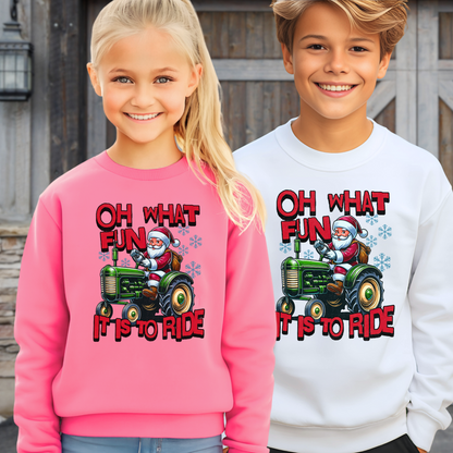 Two children, 1 boy and 1 girl wearing sweatshirts with Santa Claus and a tractor design.