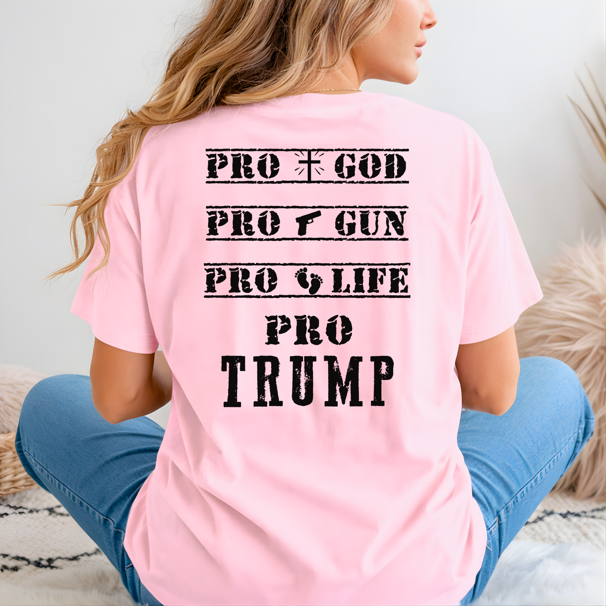 Person wearing a pink t-shirt with 'PRO GOD, PRO GUN, PRO LIFE, PRO TRUMP' text on the back.