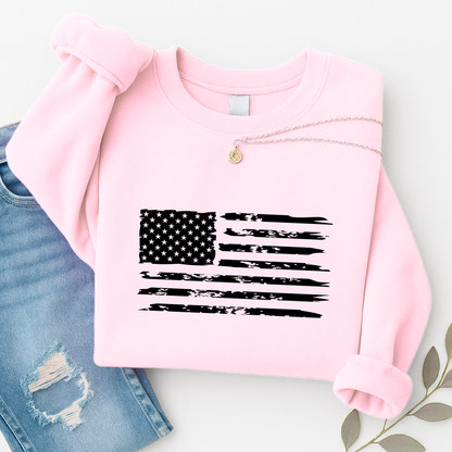 Pink sweatshirt with American flag design on a white surface with denim jeans.