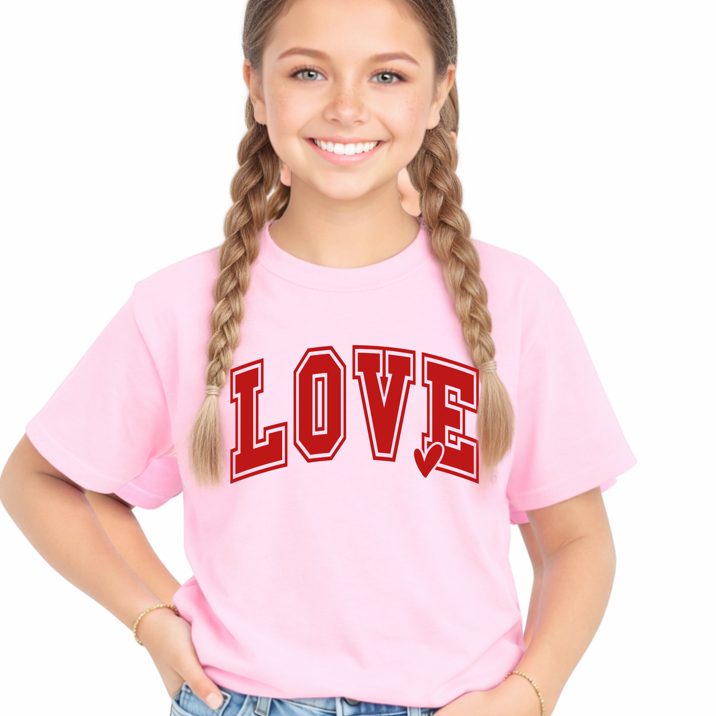 Youth girl wearing a light pink LOVE graphic t-shirt with red varsity lettering and light wash denim shorts