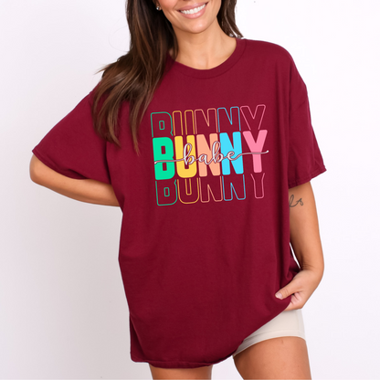 Trendy Bunny Babe graphic t-shirt with colorful pastel typography, perfect for Easter outfits, spring fashion, and casual wear. Soft cotton tee for women.
