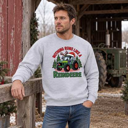 Man in a sports gray Nothing Runs Like a Reindeere sweatshirt leaning on a barn fence with a tractor behind him.