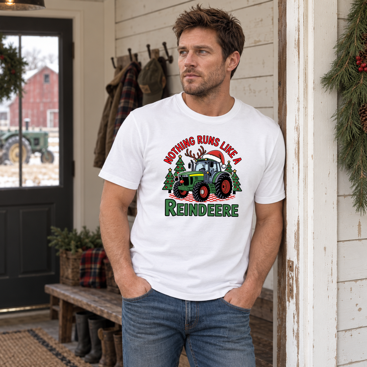 Man wearing a white Nothing Runs Like a Reindeere T-shirt in a farmhouse entryway with Christmas greenery.