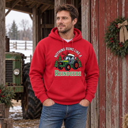 Man wearing a red Nothing Runs Like a Reindeere hoodie beside a weathered red barn and green tractor.