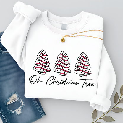 Flat lay of a white Christmas sweatshirt featuring three red and white trees with “Oh Christmas Tree” text. Styled with ripped jeans and gold necklace for a festive look.