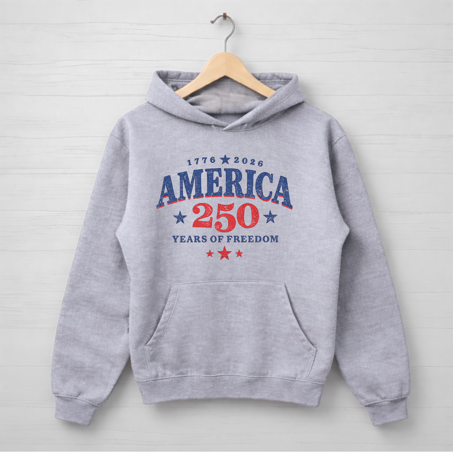 Gray hoodie with 'America 250 Years of Freedom' text on a wooden hanger against a light gray background