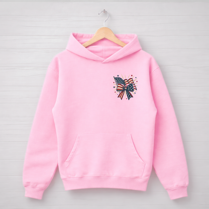 Pink hoodie with a decorative bow design on a wooden hanger against a light gray background