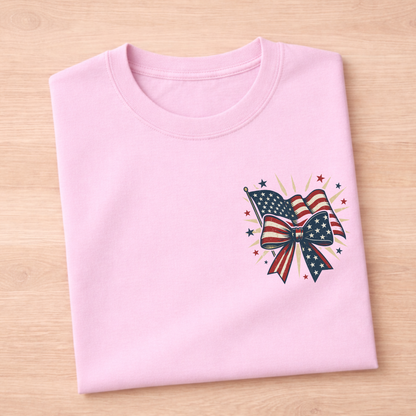 Pink t-shirt with American flag and bow design on a wooden surface