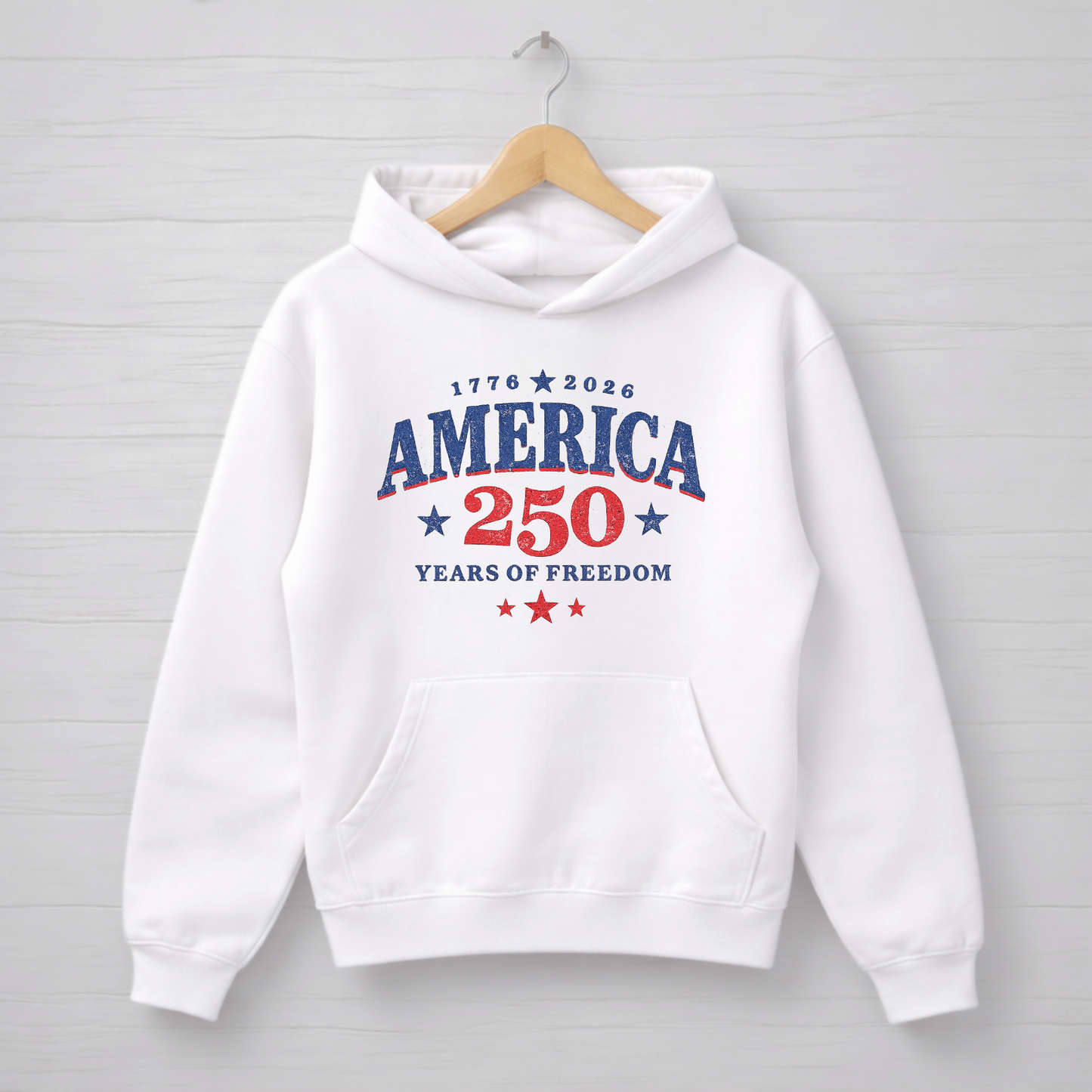 White hoodie with 'America 250 Years of Freedom' text on a wooden hanger against a light gray background