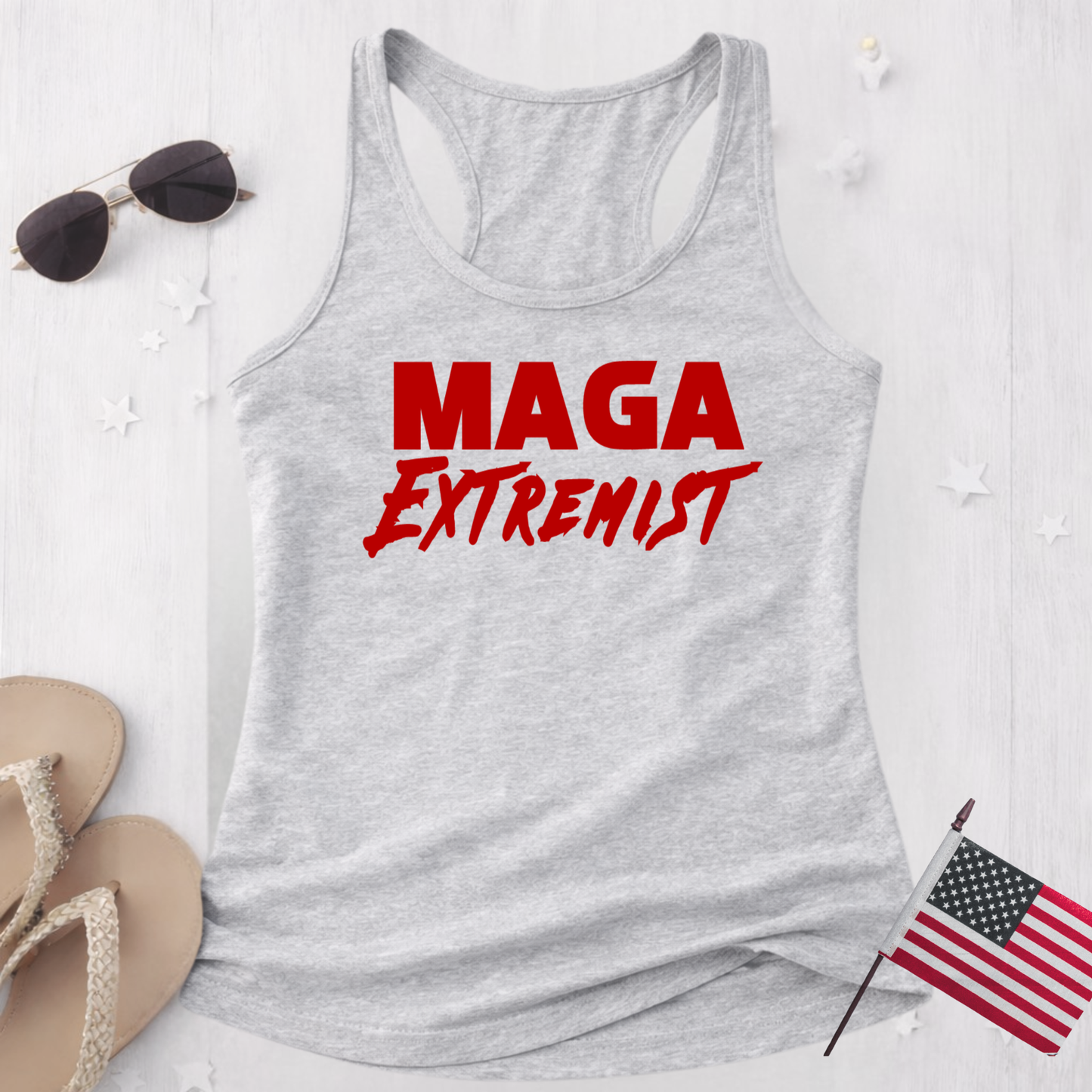 Gray tank top with 'MAGA Extremist' text on a white surface with accessories.