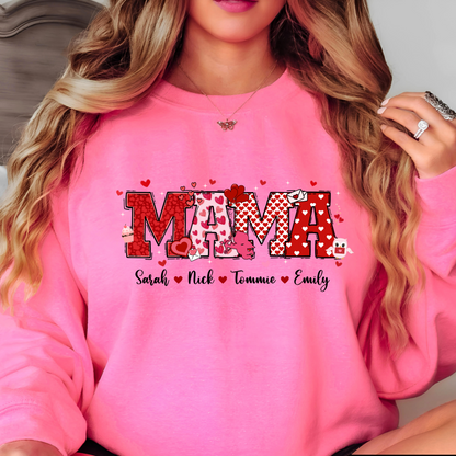 A pink sweatshirt with a personalized Valentine's Day design, including the name 'MAMA' in a decorative font, surrounded by heart shapes and small decorative elements.