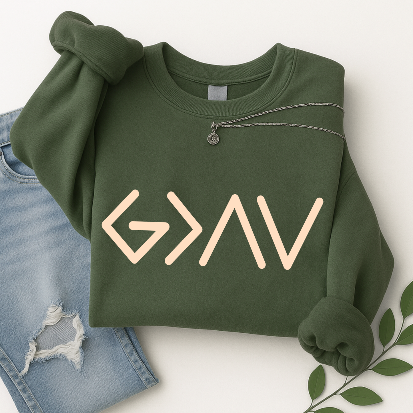 Green sweatshirt folded displaying gold God Is Greater Than the Highs and Lows front design