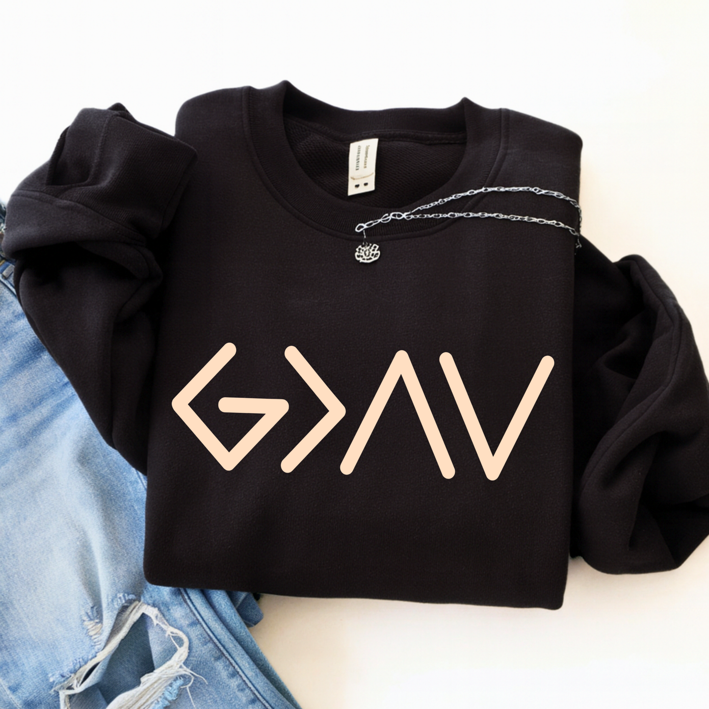 Black hoodie worn by model showing gold God Is Greater Than the Highs and Lows front design