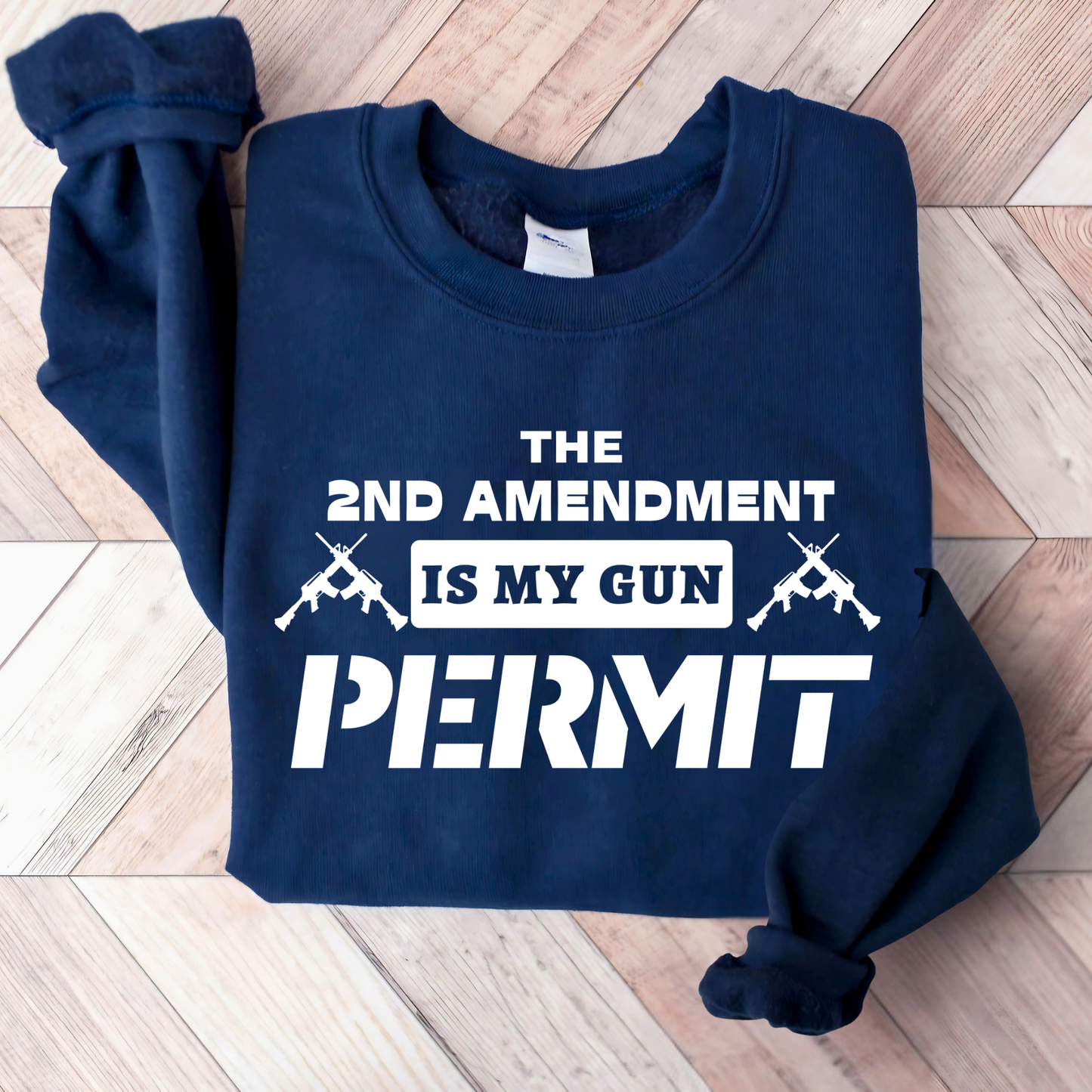 Navy blue sweatshirt with white text and graphics on a wooden floor.