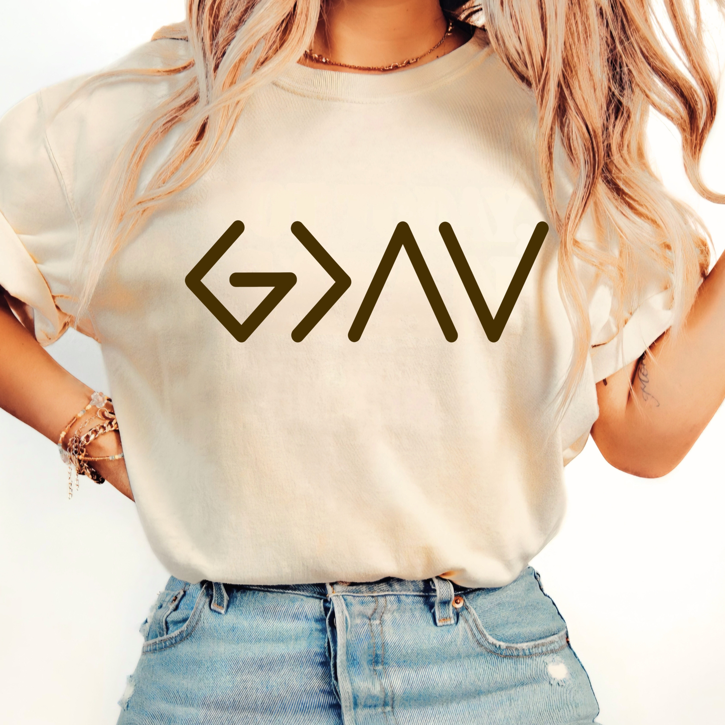 Cream short sleeve t-shirt worn by model showing gold God Is Greater Than the Highs and Lows front design