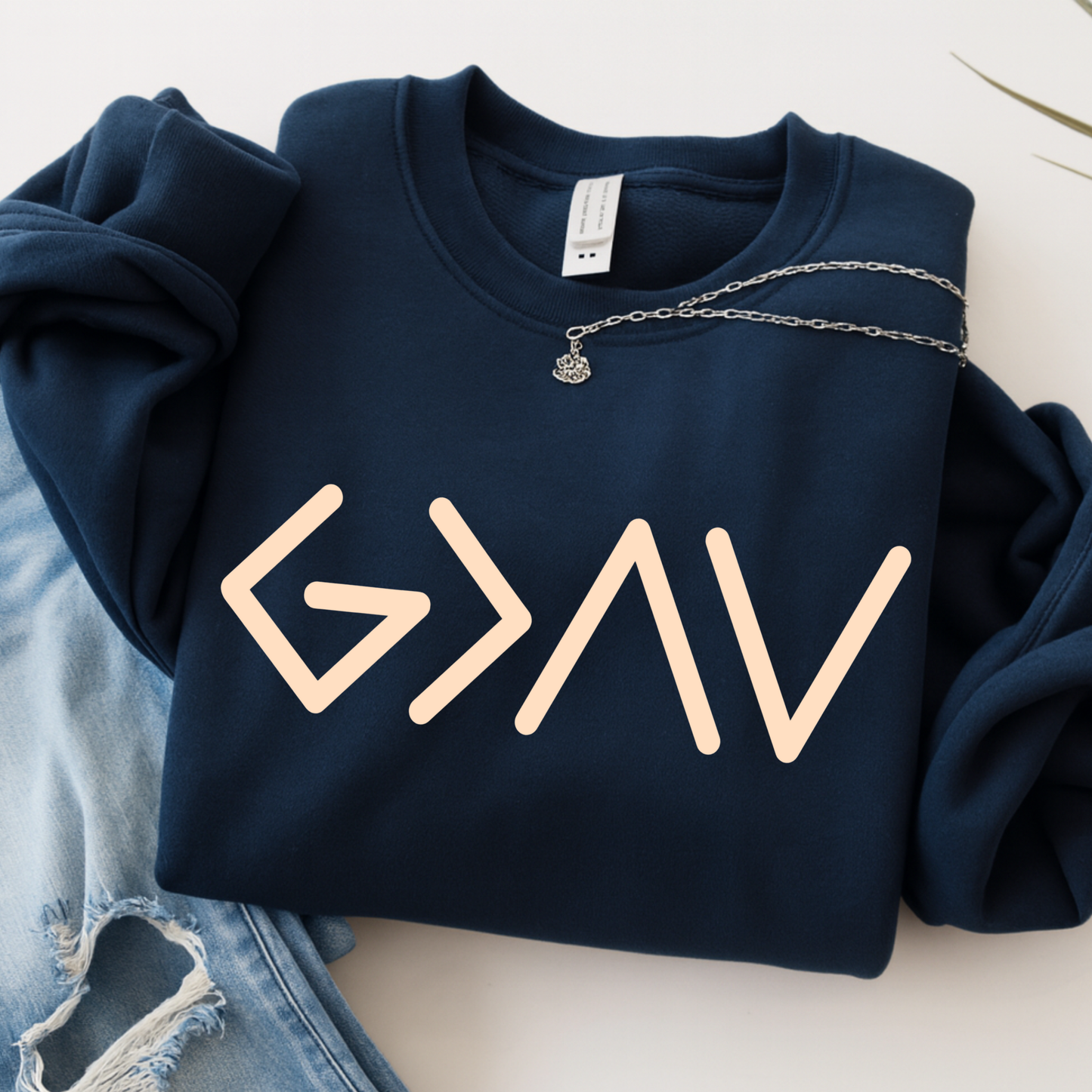 Navy hoodie folded showing gold God Is Greater Than the Highs and Lows front design on front