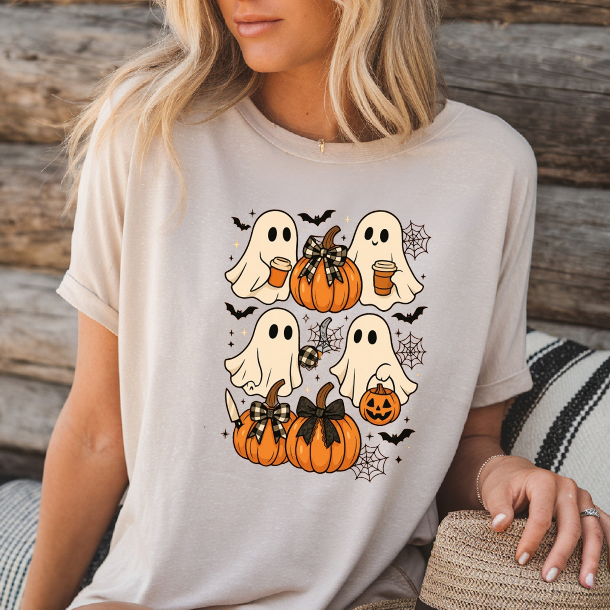 Soft cream Halloween T-shirt featuring cute ghosts with pumpkins, bats, and spiderwebs. A cozy fall tee ideal for pumpkin patch visits, casual autumn outfits, and Halloween events
