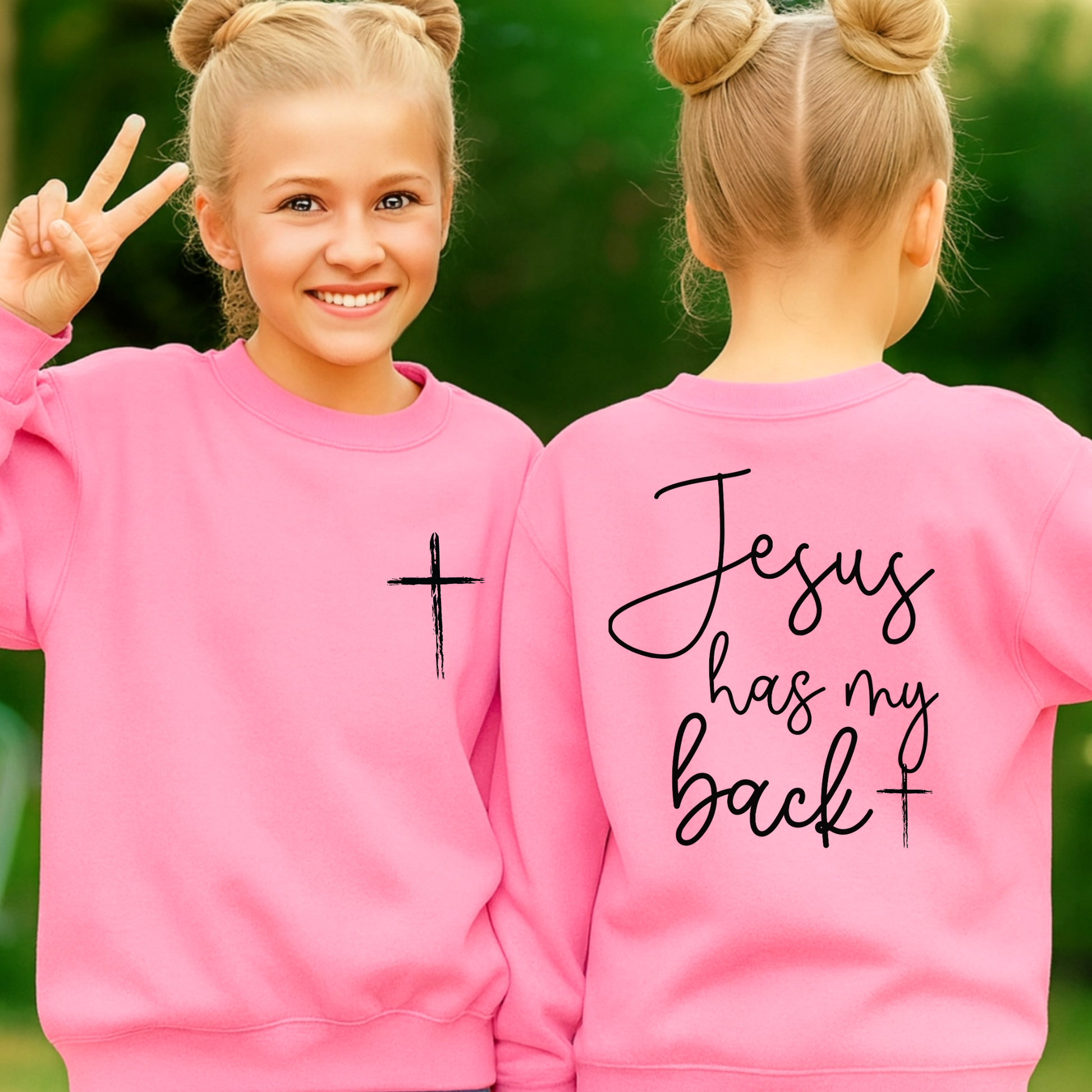 Two pink sweatshirts with a cross and 'Jesus has my back' text, worn by a girl outdoors.
