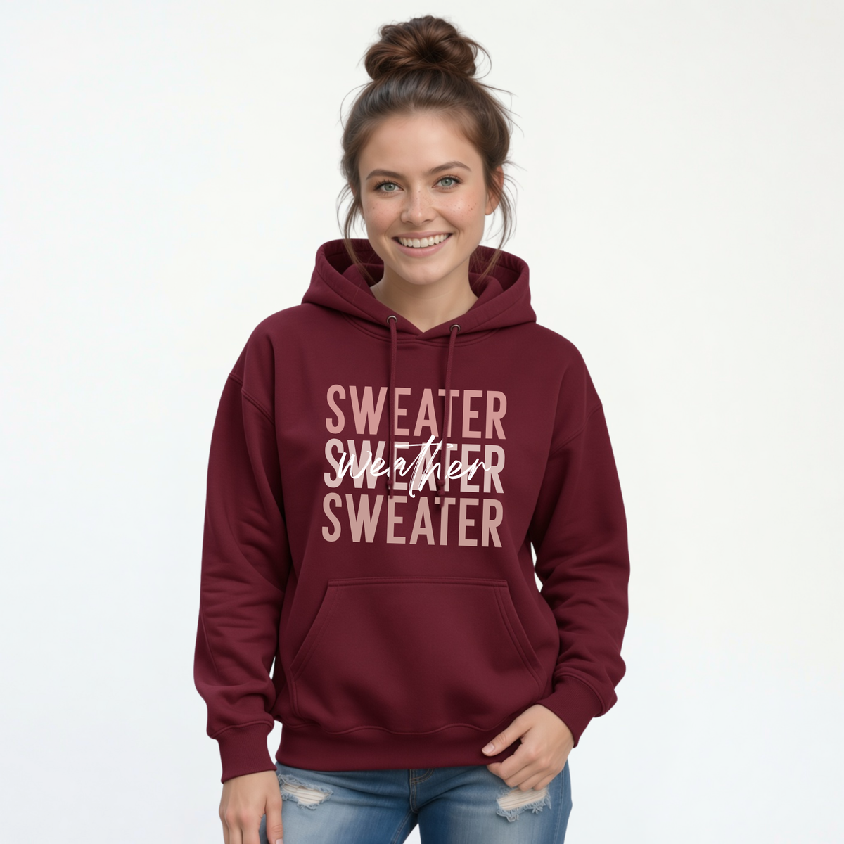 Woman wearing maroon Sweater Weather hoodie with jeans