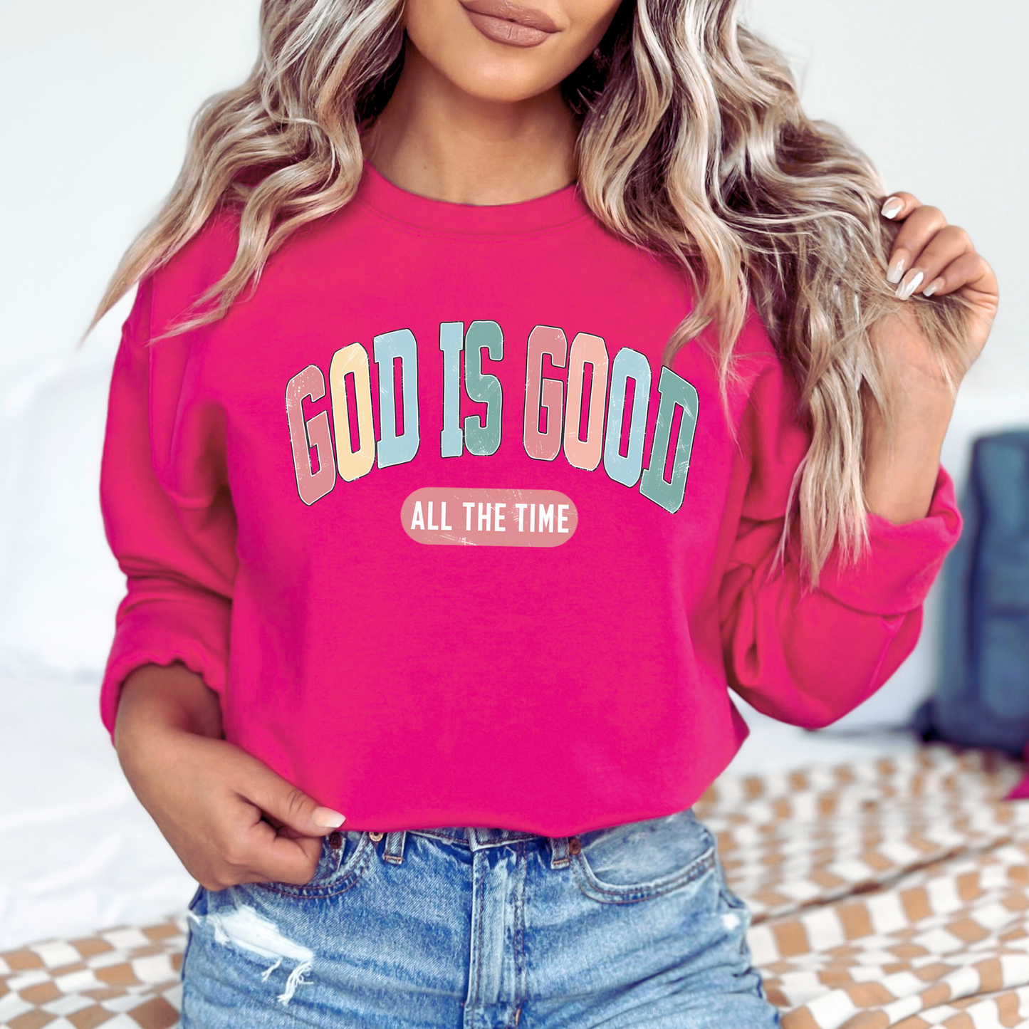Person wearing a pink sweatshirt with 'God is Good All the Time' text.