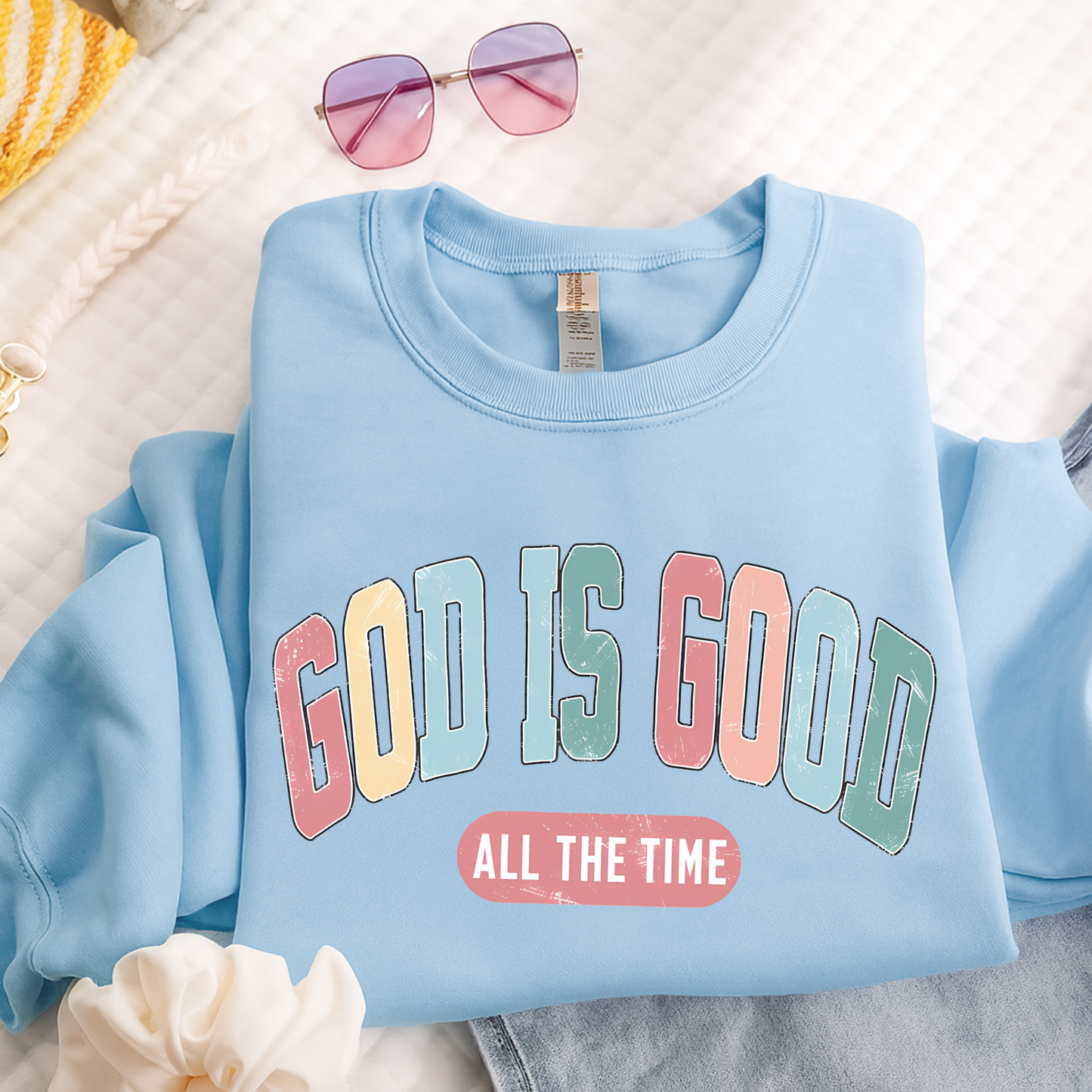 Light blue sweatshirt with 'GOD IS GOOD ALL THE TIME' text on a light background