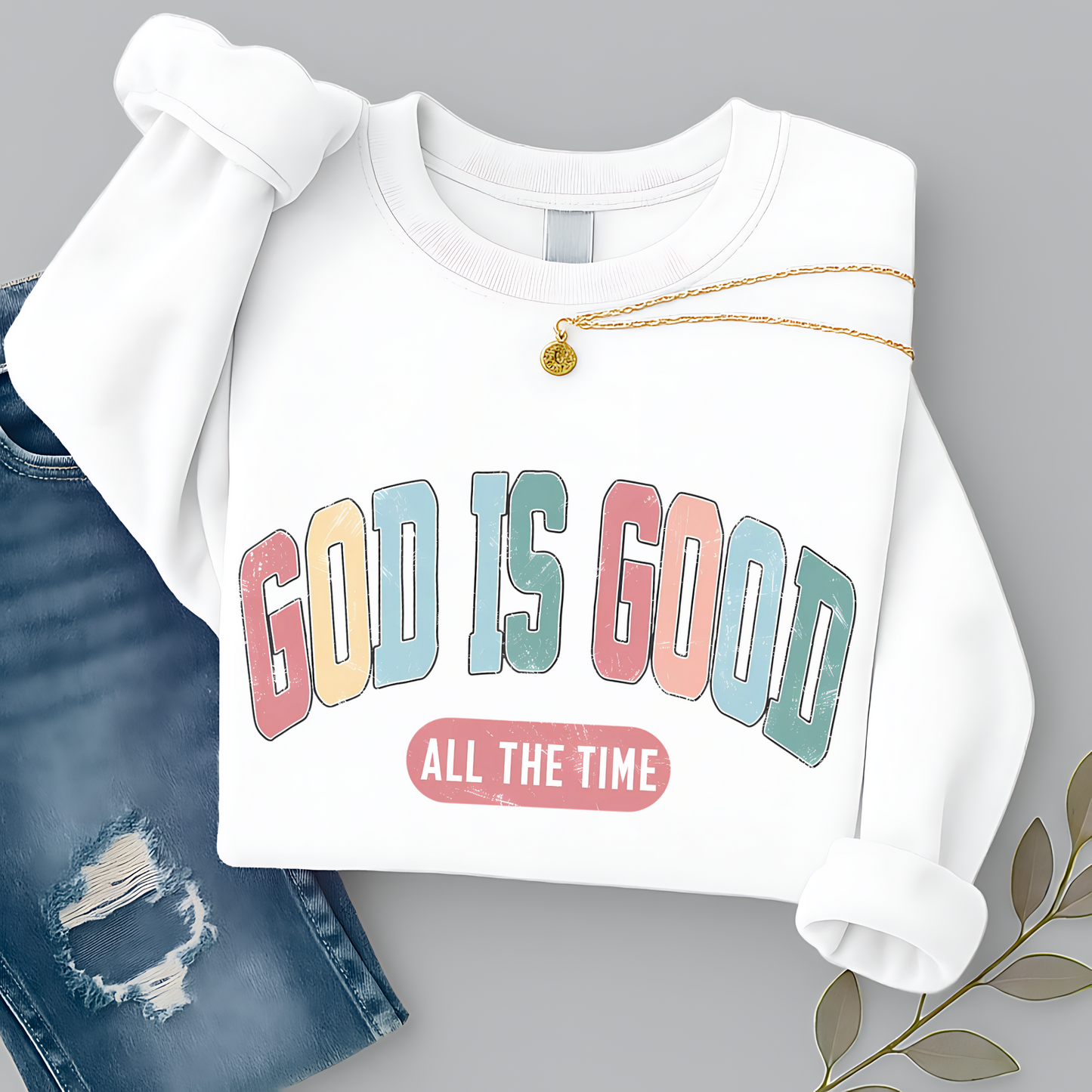White sweatshirt with 'GOD IS GOOD ALL THE TIME' text on a gray background