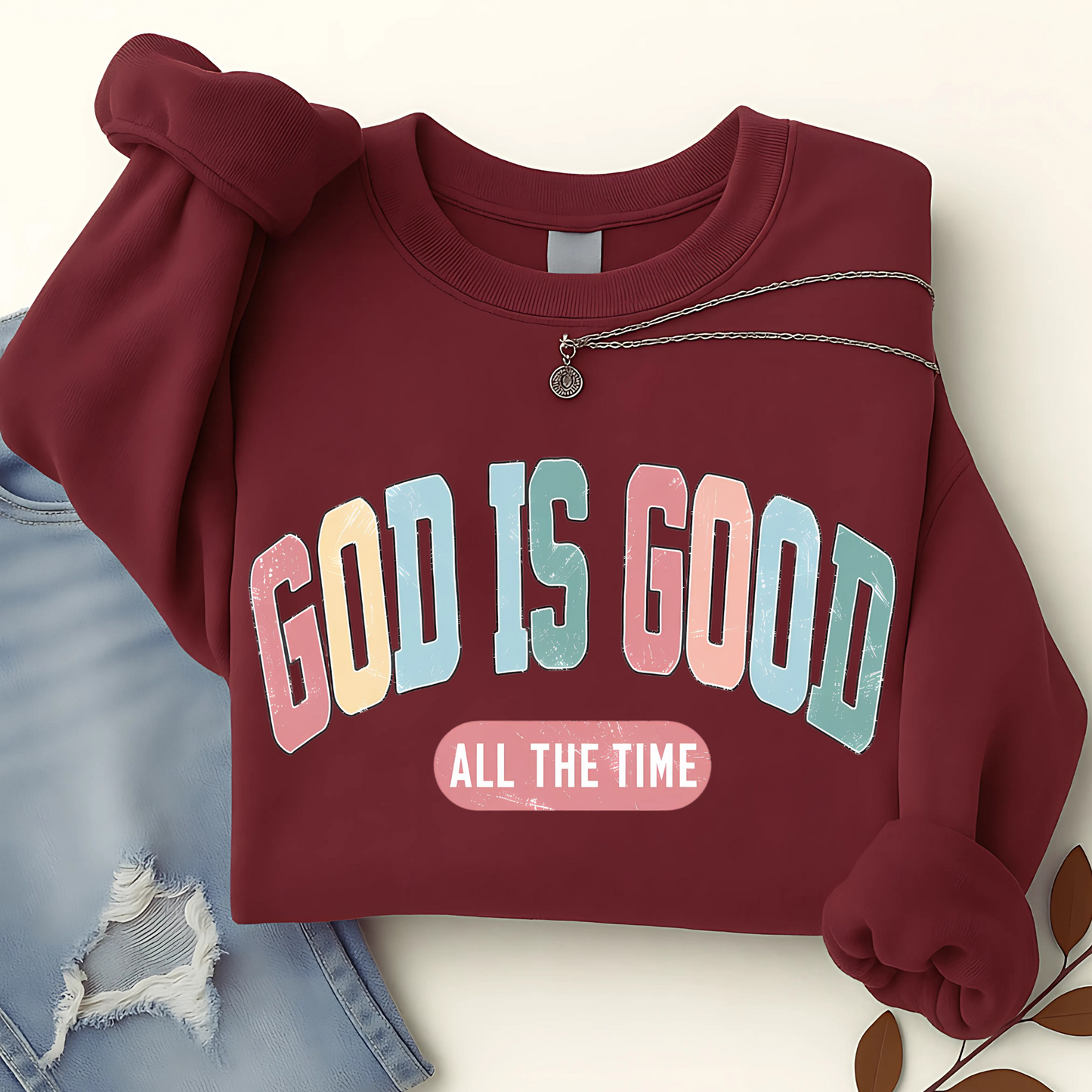 Maroon sweatshirt with 'GOD IS GOOD ALL THE TIME' text on a light background