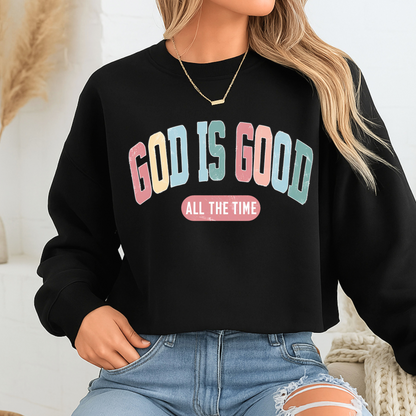 Person wearing a black sweatshirt with 'GOD IS GOOD ALL THE TIME' text in colorful letters.