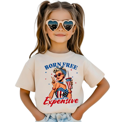 Sand color patriotic T-shirt with retro sunglasses woman in flag outfit saying Born Free But Now I'm Expensive

