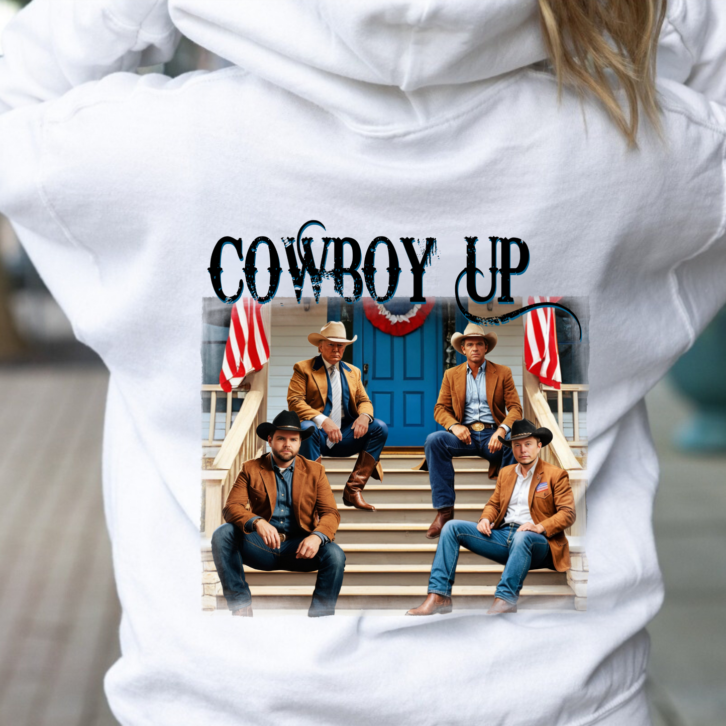 A white hoodie with a graphic print of cowboys seated on a porch with American flags and the text 'Cowboy Up' on the back and a front-left chest portrait of a cowboy with 'Cowboy Up' script.